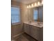 Double vanity bathroom with a large mirror and neutral tile at 727 Putney Hill Rd, Zebulon, NC 27597