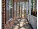 Brick front porch with white railings, offering a view of the wooded backyard at 671 Legend Oaks Dr, Chapel Hill, NC 27517