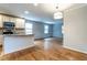 Open concept kitchen with island, hardwood floors, and access to living area at 116 Plainview Ave, Raleigh, NC 27604