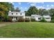 Two-house property with large yard, showcasing a white farmhouse and modern addition at 1021 Dimmocks Mill Rd, Hillsborough, NC 27278