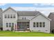 Back view of a two-story house with a screened-in porch and grassy backyard at 116 Mystic Quartz Ln, Holly Springs, NC 27540