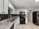 Modern kitchen with white cabinets, granite countertops, and black appliances at 5504 Skylock Dr, Raleigh, NC 27610