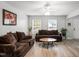 Bright living room featuring brown couches, a coffee table, and large windows at 5504 Skylock Dr, Raleigh, NC 27610