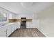 Bright kitchen featuring white cabinets, stainless steel appliances, and wood-look flooring at 204 W Hill St, Benson, NC 27504