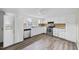 Kitchen with white cabinets, stainless steel appliances, and wood-look floors at 204 W Hill St, Benson, NC 27504