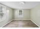 Spacious bedroom with a window, neutral walls, and light brown wood-look flooring at 204 W Hill St, Benson, NC 27504