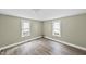 Simple bedroom with two windows and wood-look floors at 204 W Hill St, Benson, NC 27504