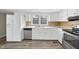 Kitchen boasts white cabinets, stainless steel appliances, and wood-look floors at 204 W Hill St, Benson, NC 27504