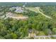 High-angle view showcasing a house surrounded by a wooded area, near a highway at 705 Jefferson St, Henderson, NC 27536