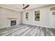 Spacious living room with hardwood floors, fireplace, and large windows at 705 Jefferson St, Henderson, NC 27536
