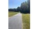 Long paved driveway with grassy areas and trees on both sides at 1150 Old County Home Rd, Nashville, NC 27856