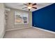 Bedroom with blue accent wall, ceiling fan, and window with blinds at 532 Lena Cir, Chapel Hill, NC 27516