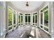 Sun-drenched sunroom with flagstone flooring and wall-to-wall windows at 6300 Swallow Cove Ln, Raleigh, NC 27614