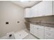 Laundry room with white cabinets and granite countertop at 6300 Swallow Cove Ln, Raleigh, NC 27614