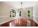 Bright dining room with hardwood floors, large windows, and elegant light fixture at 6300 Swallow Cove Ln, Raleigh, NC 27614