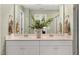 Double vanity bathroom with a large mirror and green walls at 219 Anise Ln, Garner, NC 27529