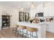 Modern kitchen with white cabinets, island, and hardwood floors at 219 Anise Ln, Garner, NC 27529