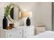 White dresser with round mirror, creating an elegant and functional bedroom space at 219 Anise Ln, Garner, NC 27529
