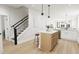 Kitchen island with a staircase and light-colored cabinets in the background at 2408 Adrift Road, Fuquay Varina, NC 27526