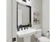 Modern bathroom with white pedestal sink, black accents, and framed mirror at 2408 Adrift Road, Fuquay Varina, NC 27526