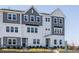 3 story townhome with gray and white siding, and a landscaped front yard at 1206 Holding Village Way, Wake Forest, NC 27587