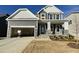 New construction home with gray siding, stone accents, and a two-car garage at 1528 Maelyn Way, Fuquay Varina, NC 27526