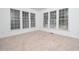 Bright sunroom with multiple windows and neutral carpeting at 4621 Easthampton Dr, Raleigh, NC 27604