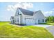 Gray farmhouse exterior with white trim, a large two-car garage, and a well-manicured lawn at Tbd 1 Cedar Lane Rd, Sanford, NC 27332