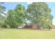 Brick house with mature trees and a large yard at 2171 Bud Lipscomb Rd, Willow Springs, NC 27592