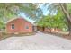 Brick ranch home with gravel driveway and mature landscaping at 2171 Bud Lipscomb Rd, Willow Springs, NC 27592