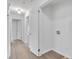 Clean hallway with light hardwood floors and access to other rooms at 2171 Bud Lipscomb Rd, Willow Springs, NC 27592