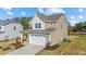 Two-story house with neutral siding, white garage doors, and landscaping at 36 Railcar Way, Clayton, NC 27520