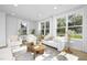 Bright living room features a comfy sofa and chairs, a coffee table, and large windows at 2411 Adrift Rd, Fuquay Varina, NC 27526