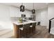 Modern kitchen with white cabinets, an island, and contemporary lighting at 2415 Adrift Rd, Fuquay Varina, NC 27526