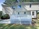 Two story house with light beige siding, a deck, and landscaping at 27 Pine Croft Rd, Angier, NC 27501