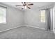 Bedroom with gray carpet, ceiling fan, and two windows at 3204 Idlewood Village Dr, Raleigh, NC 27610