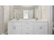 Bright bathroom with double vanity, white cabinets, and a large mirror at 7814 Nc 27, Coats, NC 27521