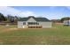 Exterior view of the back of a house with a small wooden deck and a grassy lawn at 7814 Nc 27, Coats, NC 27521