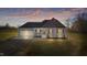 Charming green two-story home at dusk with a two-car garage and large front yard at 7814 Nc 27, Coats, NC 27521
