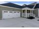 View of attached two-car garage, a covered entryway, and front yard of house at 7814 Nc 27, Coats, NC 27521