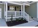 Welcoming front porch with white railing and stairs leading to the entrance at 7814 Nc 27, Coats, NC 27521