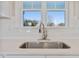 Kitchen sink with stainless steel faucet, white countertops, and subway tile backsplash at 7814 Nc 27, Coats, NC 27521