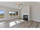 Bright living room with fireplace, wood-look floors, and large windows with backyard view at 7814 Nc 27, Coats, NC 27521