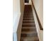 Carpeted staircase with a dark wood handrail at 758 Dorset Stream Dr, Fuquay Varina, NC 27526
