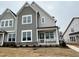 Front of new construction home with gray siding, white trim, and covered porch at 3185 Mission Olive Pl # 348, New Hill, NC 27562