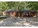 Brick ranch house with a wooden front porch and a gravel driveway at 118 W Silver Belle Dr, Zebulon, NC 27597