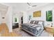 Bright bedroom with king bed, hardwood floors, and a large mirror at 1511 Malta Ave, Raleigh, NC 27610