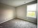 Bright bedroom with neutral walls and carpet, featuring a window with natural light at 223 Bonsai Way, Four Oaks, NC 27524