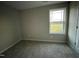 Well-lit bedroom featuring neutral carpeting and a window at 223 Bonsai Way, Four Oaks, NC 27524