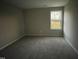 Simple bedroom with neutral carpeting and a window at 223 Bonsai Way, Four Oaks, NC 27524